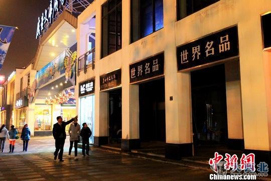 散步路过常熟市民在指点已关门的“世界名品店”。　李克祥　摄